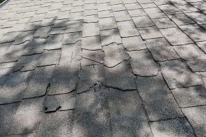 Storm damage across an asphalt shingle roof