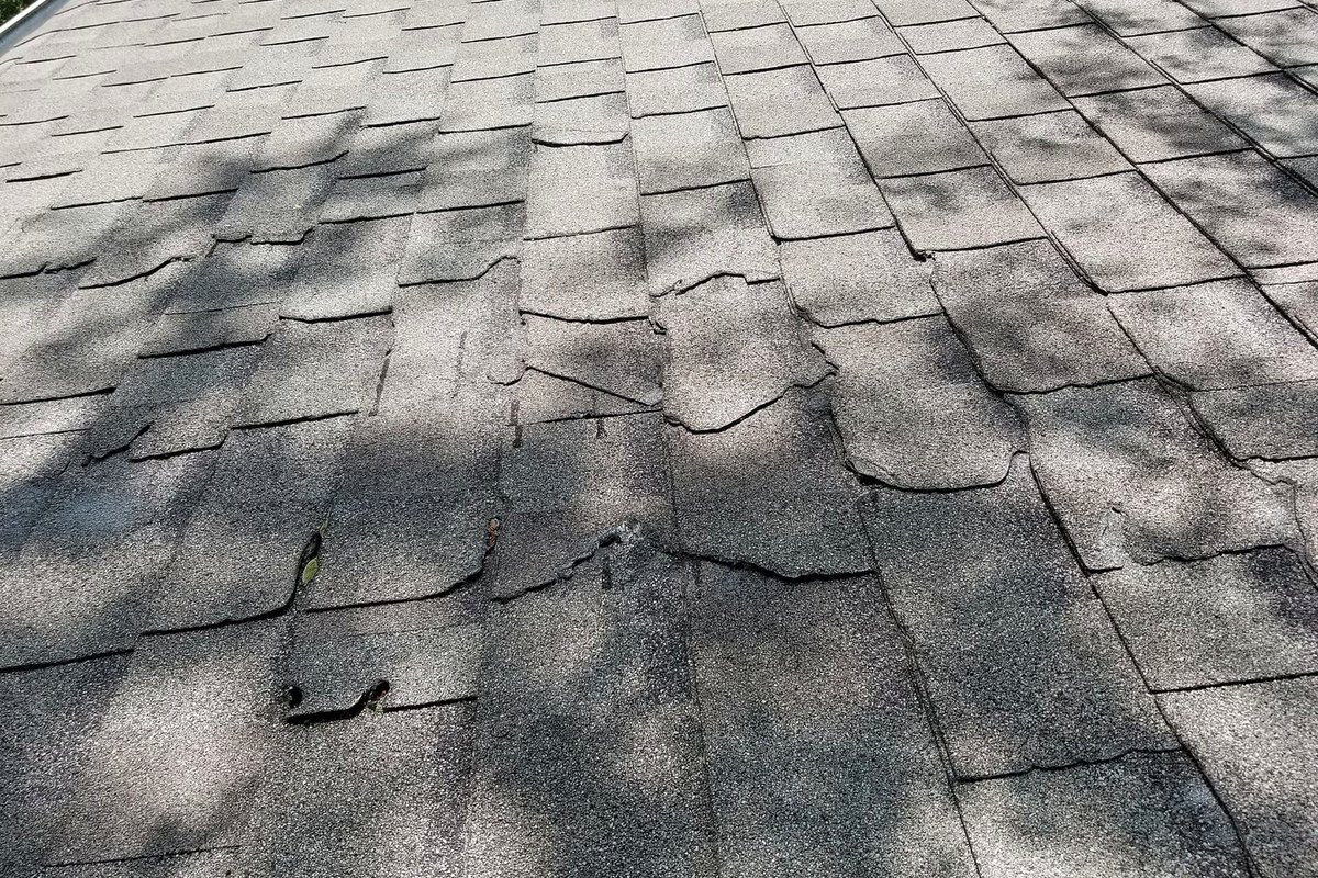 Storm damage across an asphalt shingle roof