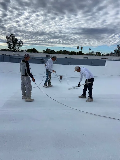 Circle G Roofing crew applying protective coating over a new foam roof