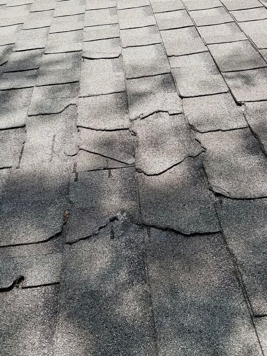 Storm damage across an asphalt shingle roof